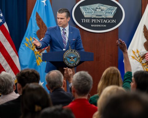 Pentagon press briefing room with Secretary Hegseth at DoD podium as reporters raise questions, Washington DC