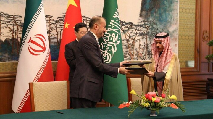 Saudi national security adviser Musaad Al-Aiban and Iranian SNSC Secretary Ali Shamkhani exchange the joint statement at the 2023 Beijing normalization signing, with Chinese Foreign Minister Wang Yi overseeing