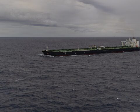 A crude oil tanker transits at sea in 2026, viewed from the port side — vessels of this class carry roughly two million barrels of crude per loaded voyage through the Strait of Hormuz