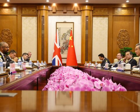 Chinese Foreign Minister Wang Yi chairs a bilateral meeting at the Chinese Ministry of Foreign Affairs in Beijing, with UK and Chinese flags visible across the diplomatic table