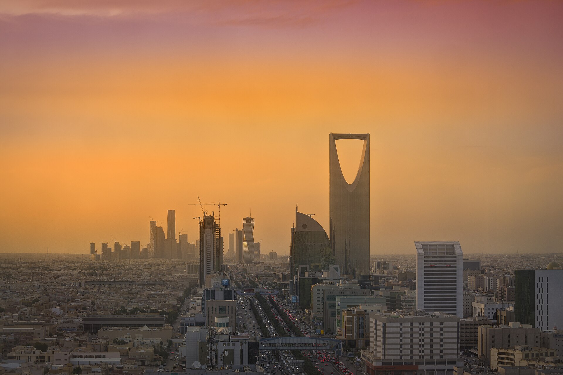 Riyadh skyline at dusk showing the King Abdullah Financial District towers under construction and the Kingdom Tower, symbols of Saudi Vision 2030 ambitions