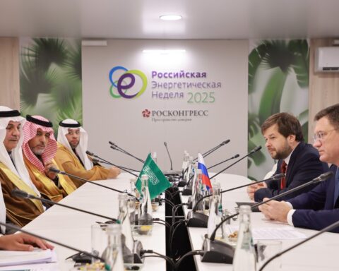 Saudi Energy Minister Prince Abdulaziz bin Salman meets with Russian Energy Minister Alexander Novak at the Russian Energy Week 2025 conference, Saudi and Russian flags on the table