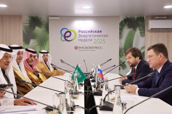 Saudi Energy Minister Prince Abdulaziz bin Salman meets with Russian Energy Minister Alexander Novak at the Russian Energy Week 2025 conference, Saudi and Russian flags on the table