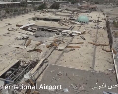 Aden International Airport terminal building gutted by war damage in July 2017, showing collapsed roof and debris across the entire structure