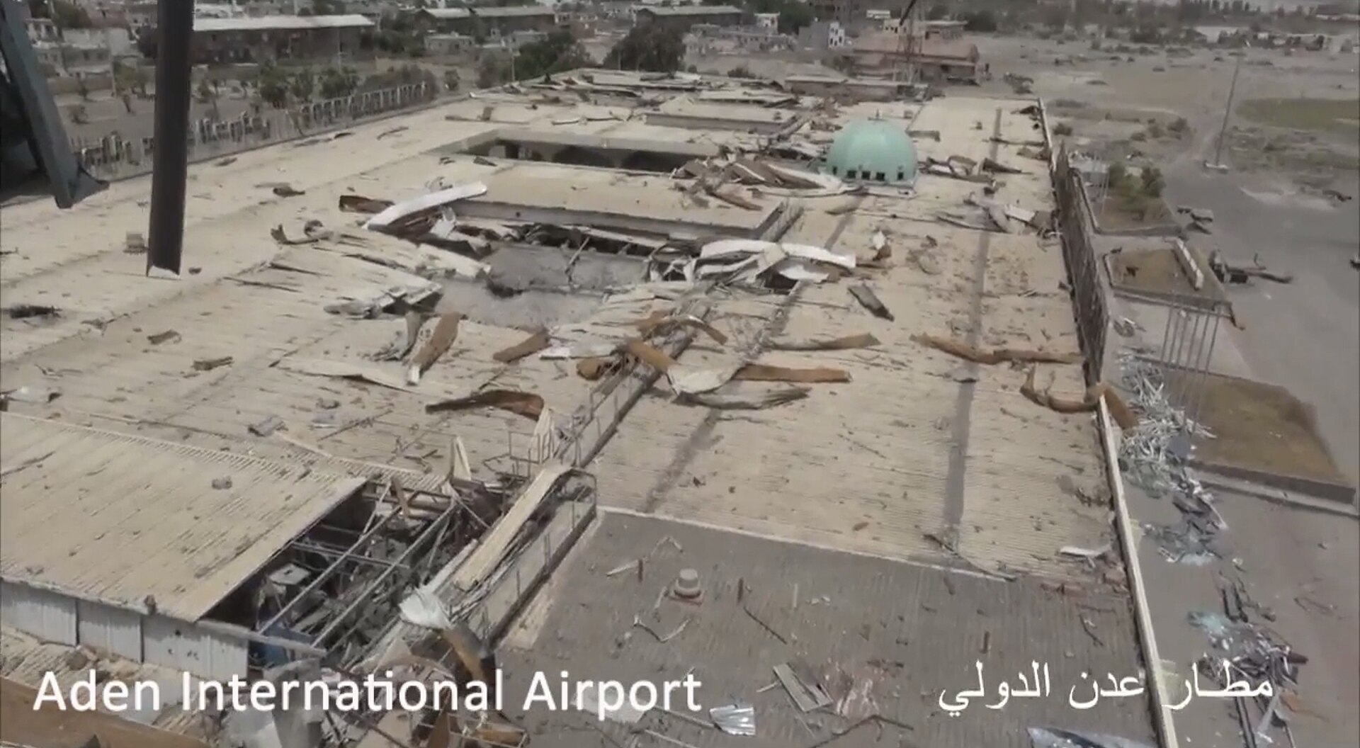 Aden International Airport terminal building gutted by war damage in July 2017, showing collapsed roof and debris across the entire structure