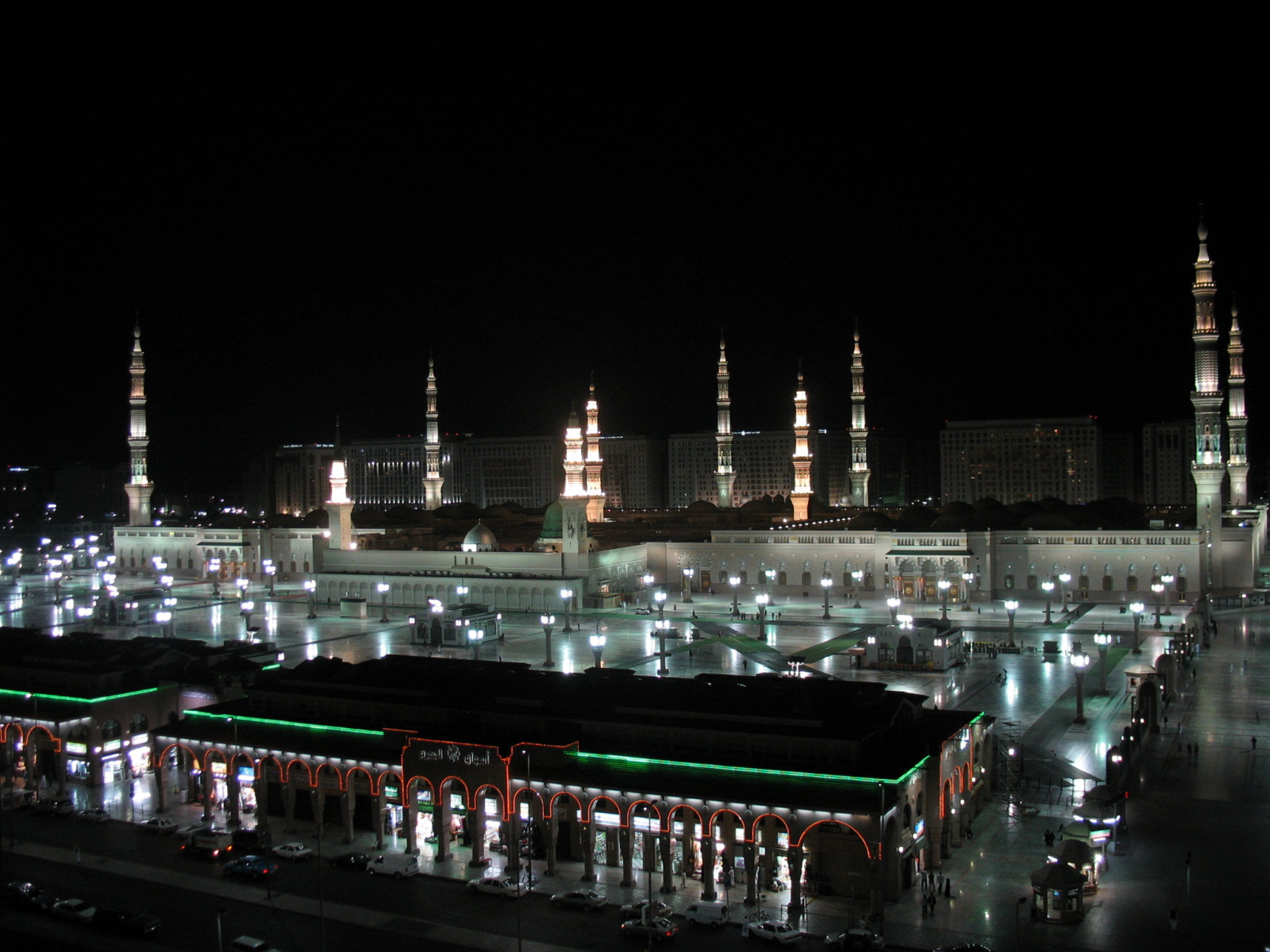 Al-Masjid an-Nabawi (the Prophet's Mosque) illuminated at night in Madinah, Saudi Arabia, with the surrounding plaza and minarets