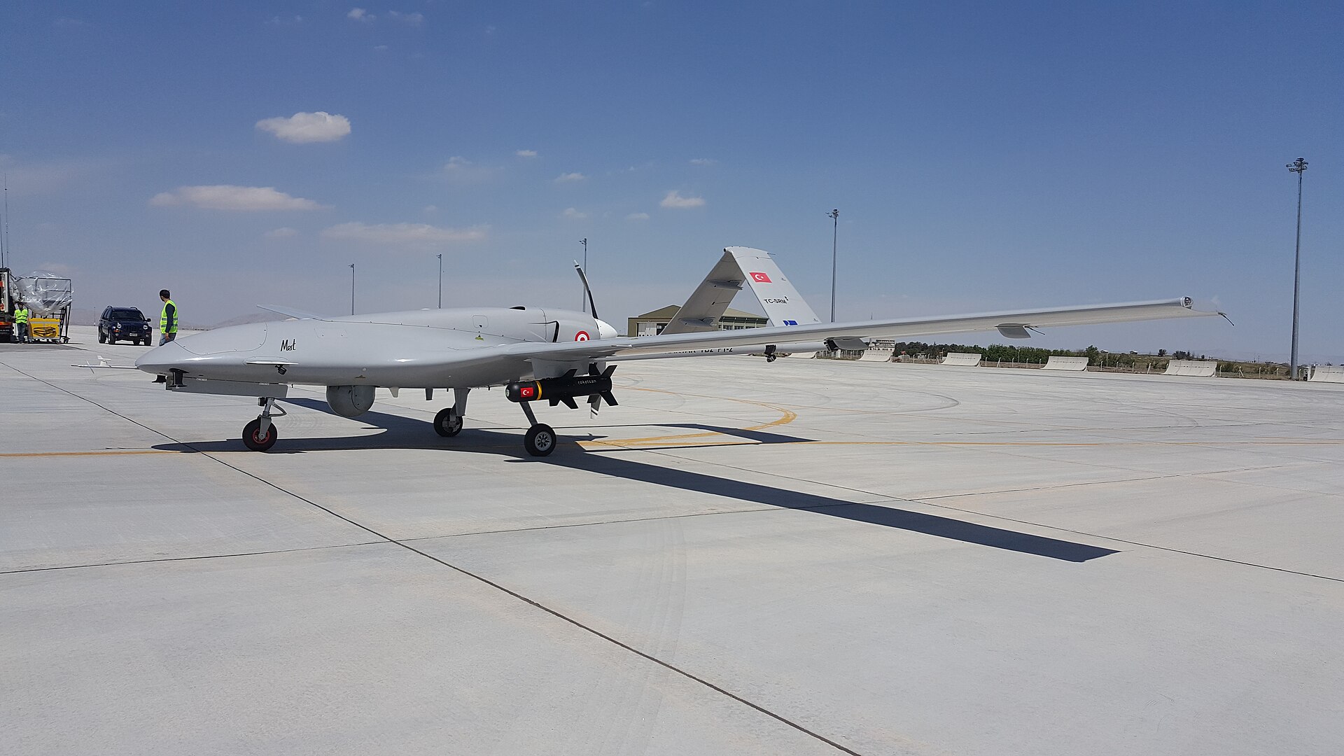Turkish Bayraktar TB2 armed drone on an airfield, Turkish flag visible on the tail and munition — the air system analysts identify as Turkey's most likely contribution to Saudi air defence