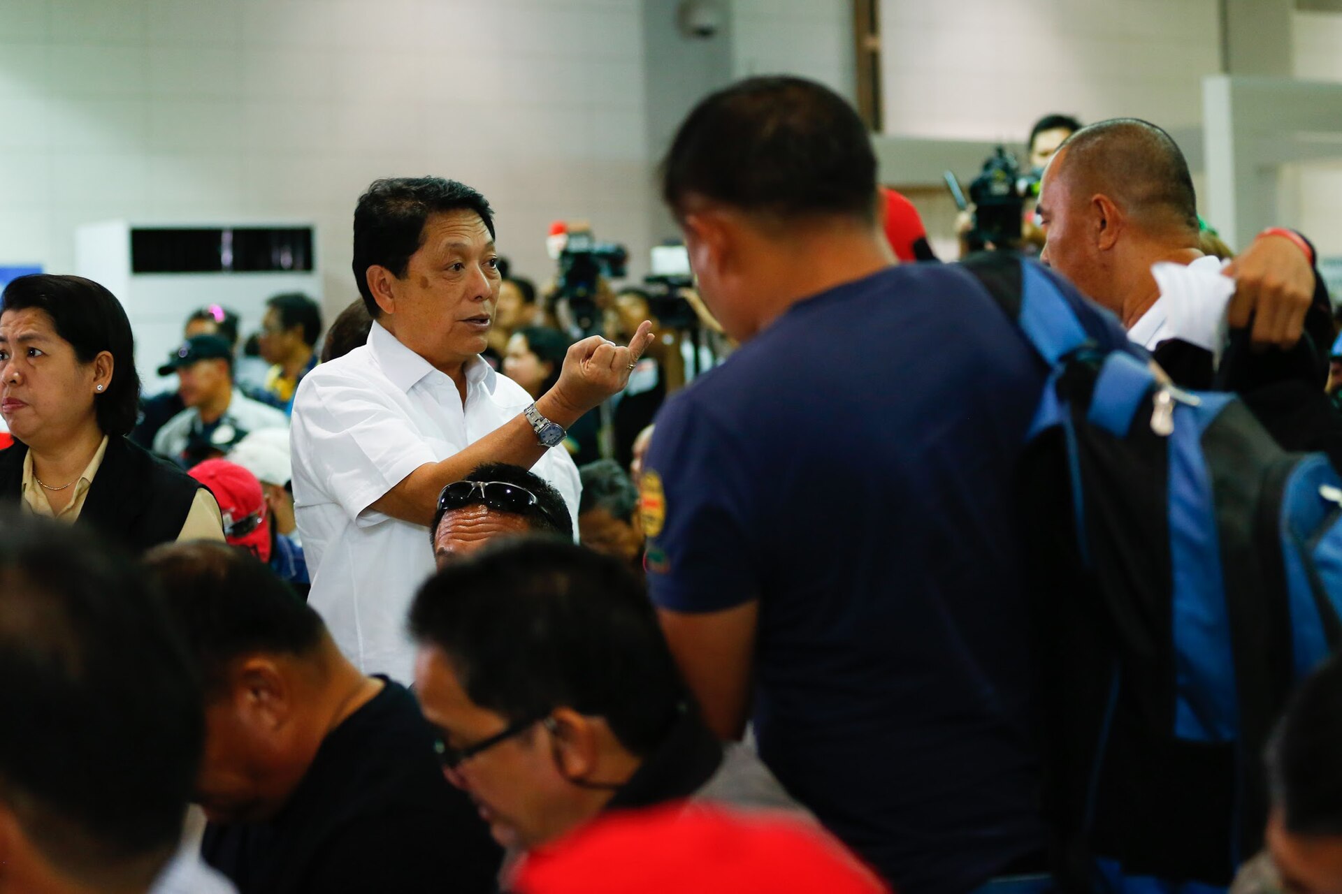 Philippine Labor Secretary Silvestre Bello III talks to repatriated overseas Filipino workers from Saudi Arabia at Ninoy Aquino International Airport, Manila