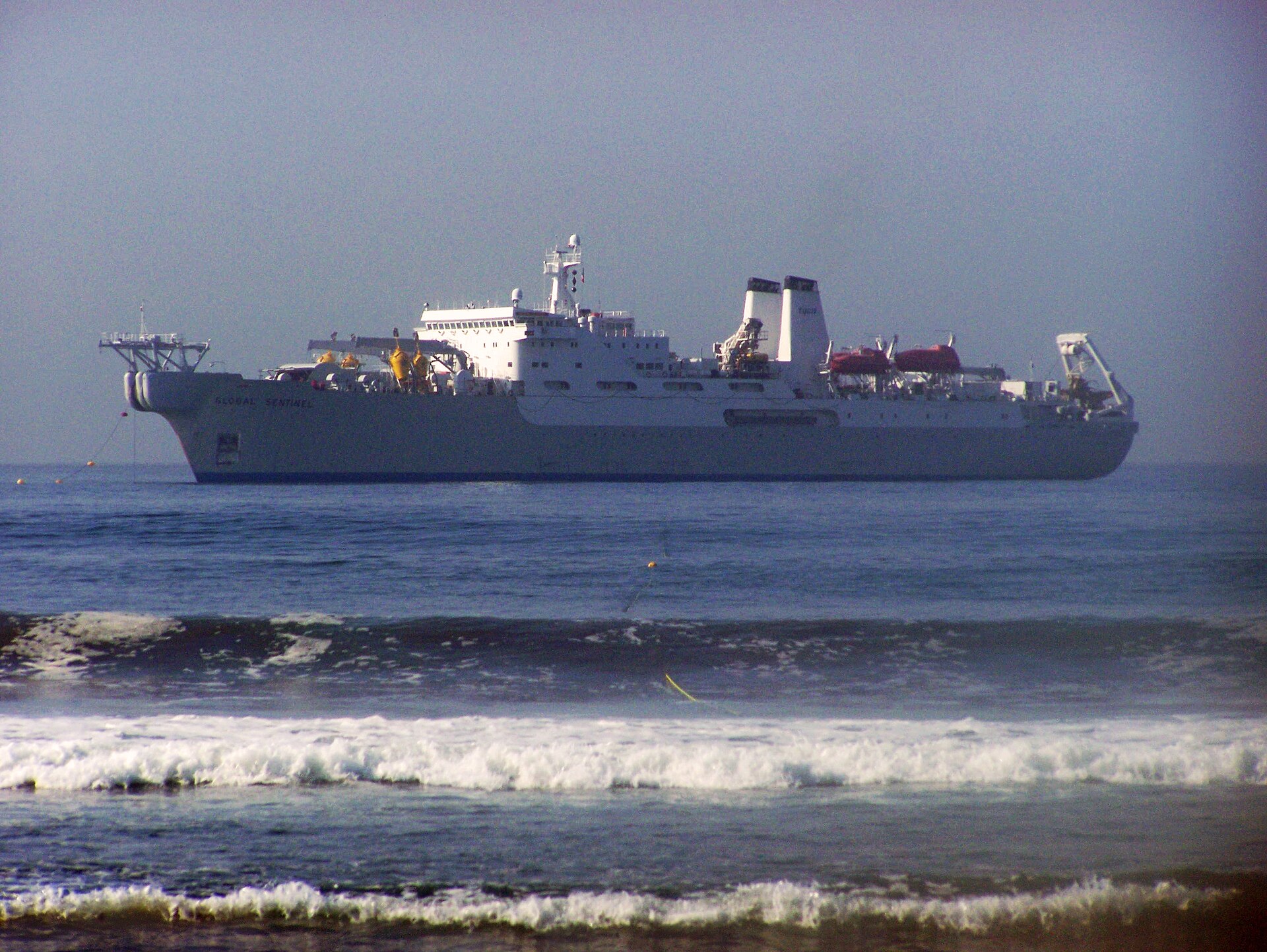 Cable ship Global Sentinel, operated by Tyco Submarine Systems, laying a submarine cable system at sea — the type of vessel that would be required for any repair of severed cables in the Strait of Hormuz