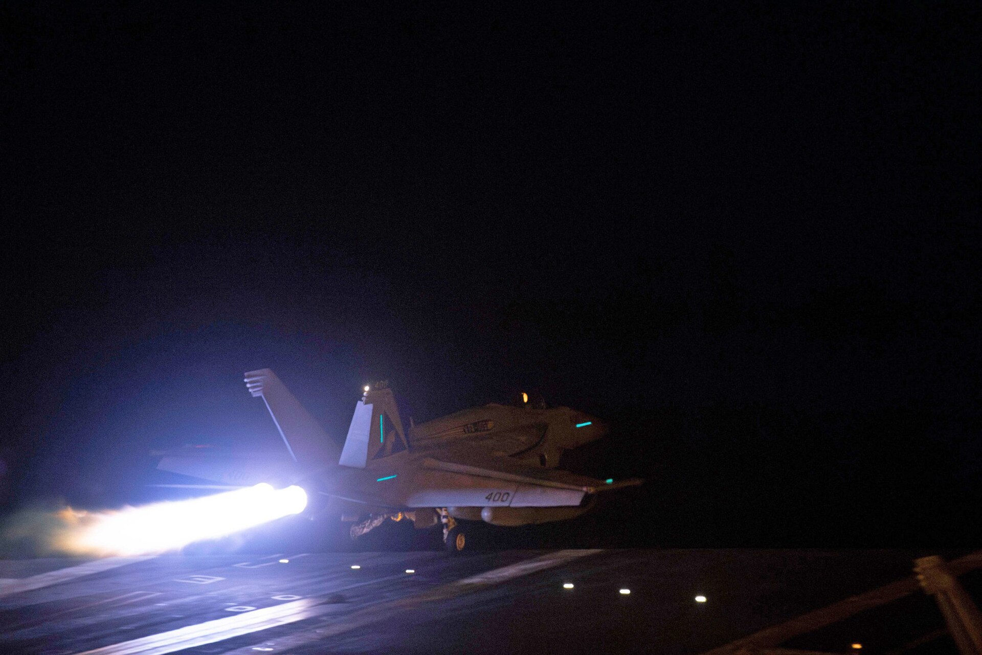 A US Navy F/A-18 Super Hornet launches from an aircraft carrier at night ahead of coalition strikes on Houthi targets in Yemen in January 2024