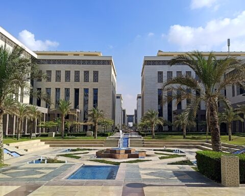 Egypt New Administrative Capital government district — modern limestone buildings with central plaza and palm trees