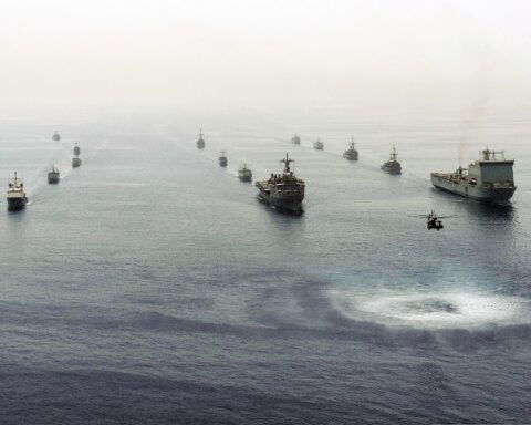 Multinational mine countermeasures ships in formation in the Persian Gulf during International Mine Countermeasures Exercise (IMCMEX) 2013, with an MH-53E Sea Dragon helicopter in the foreground