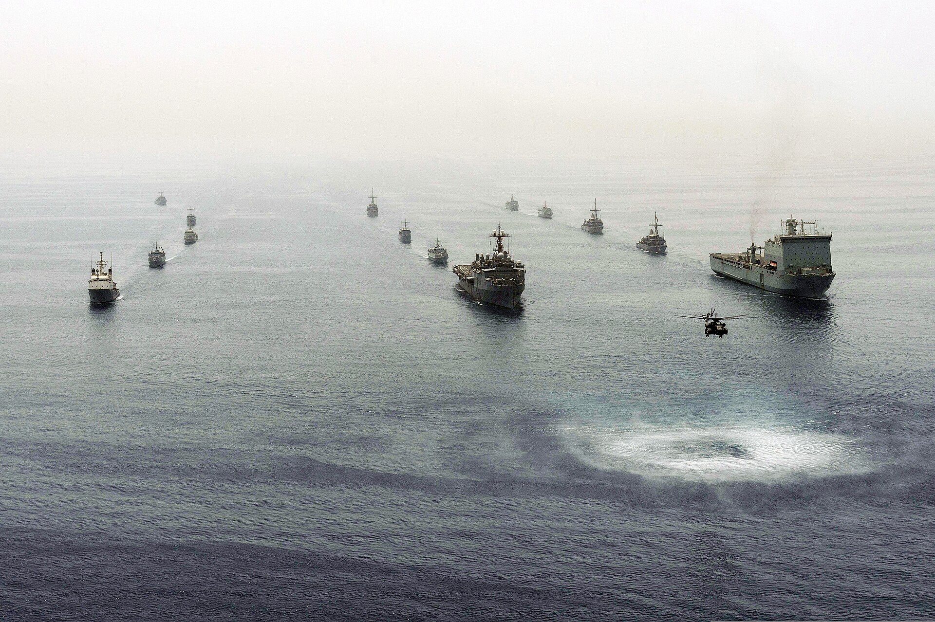 Multinational mine countermeasures ships in formation in the Persian Gulf during International Mine Countermeasures Exercise (IMCMEX) 2013, with an MH-53E Sea Dragon helicopter in the foreground