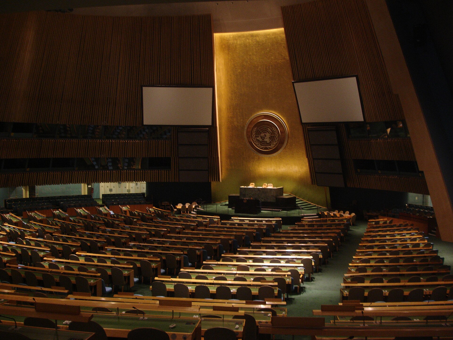 Empty United Nations General Assembly hall with blank screens and vacant seats