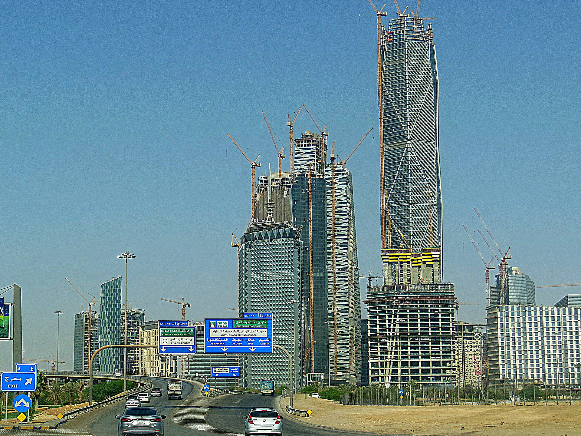 King Abdullah Financial District under construction in Riyadh — the giga-project that exemplified Vision 2030 ambition, with NEOM contracts terminated and The Line halted until after 2030 during the war