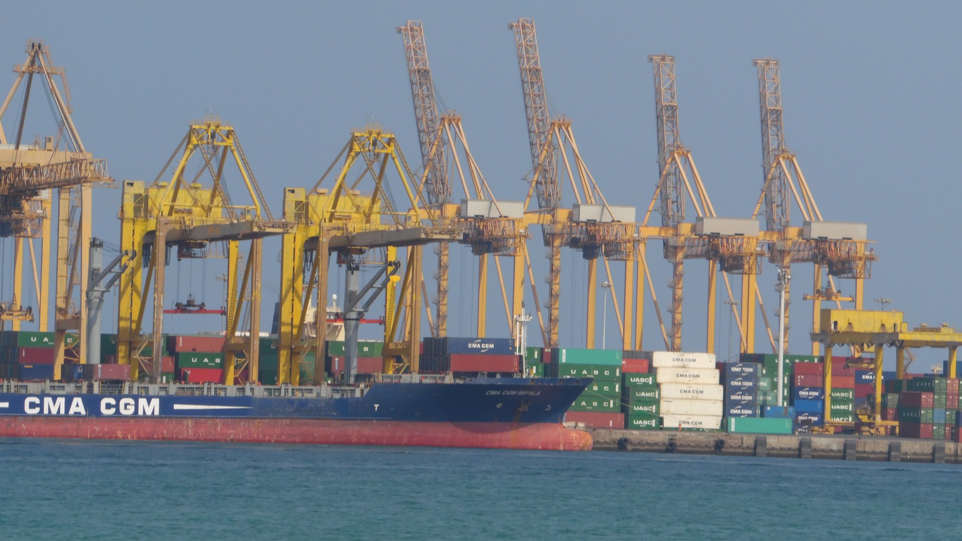 Khor Fakkan container terminal on the UAE eastern seaboard facing the Gulf of Oman, with CMA CGM vessel and loading cranes