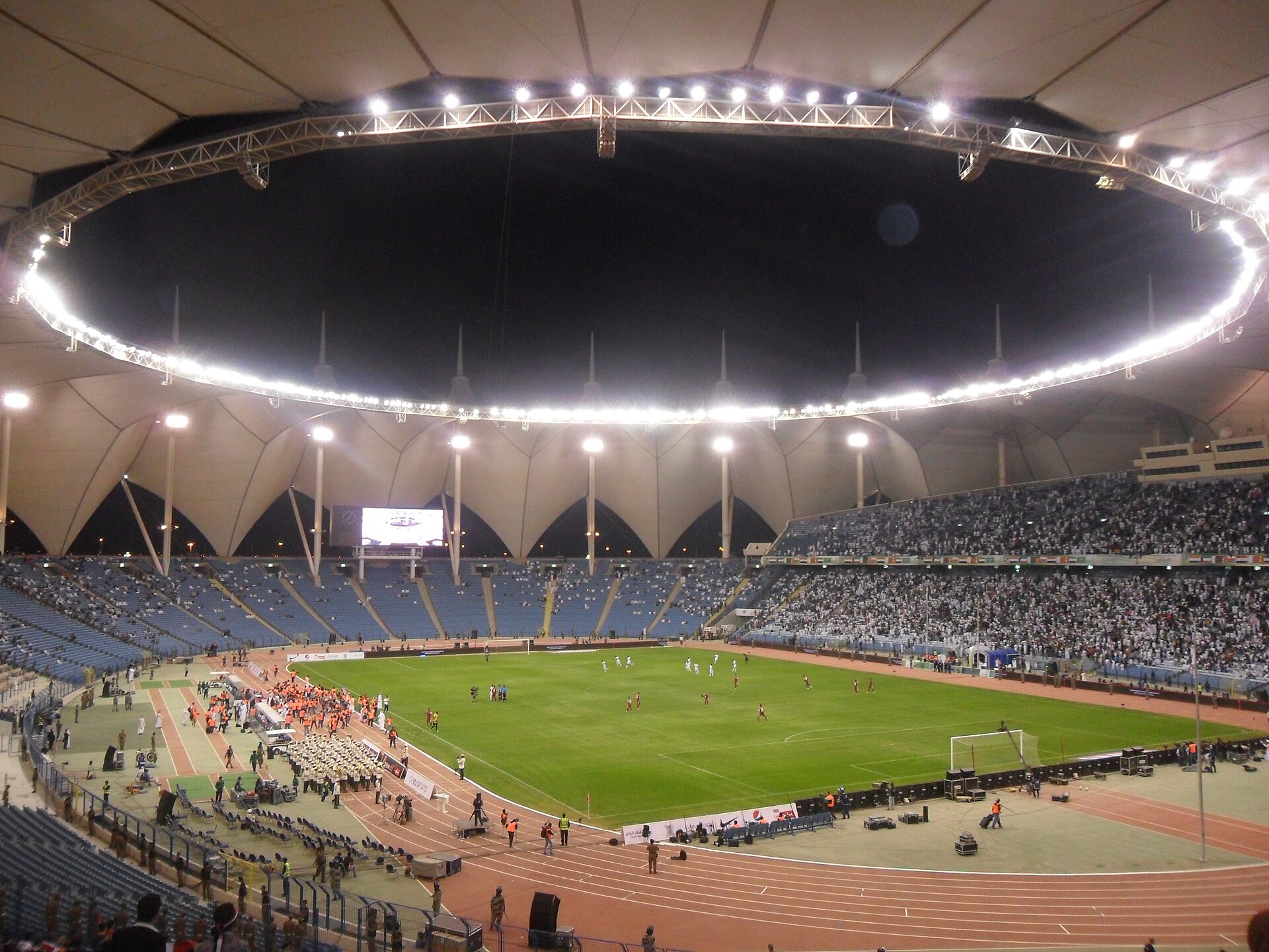 King Fahd International Stadium interior during the 22nd Arabian Gulf Cup opening match in 2014, showing the stadium's capacity crowd under its distinctive circular roof — a 2034 World Cup retained venue targeted for major refurbishment