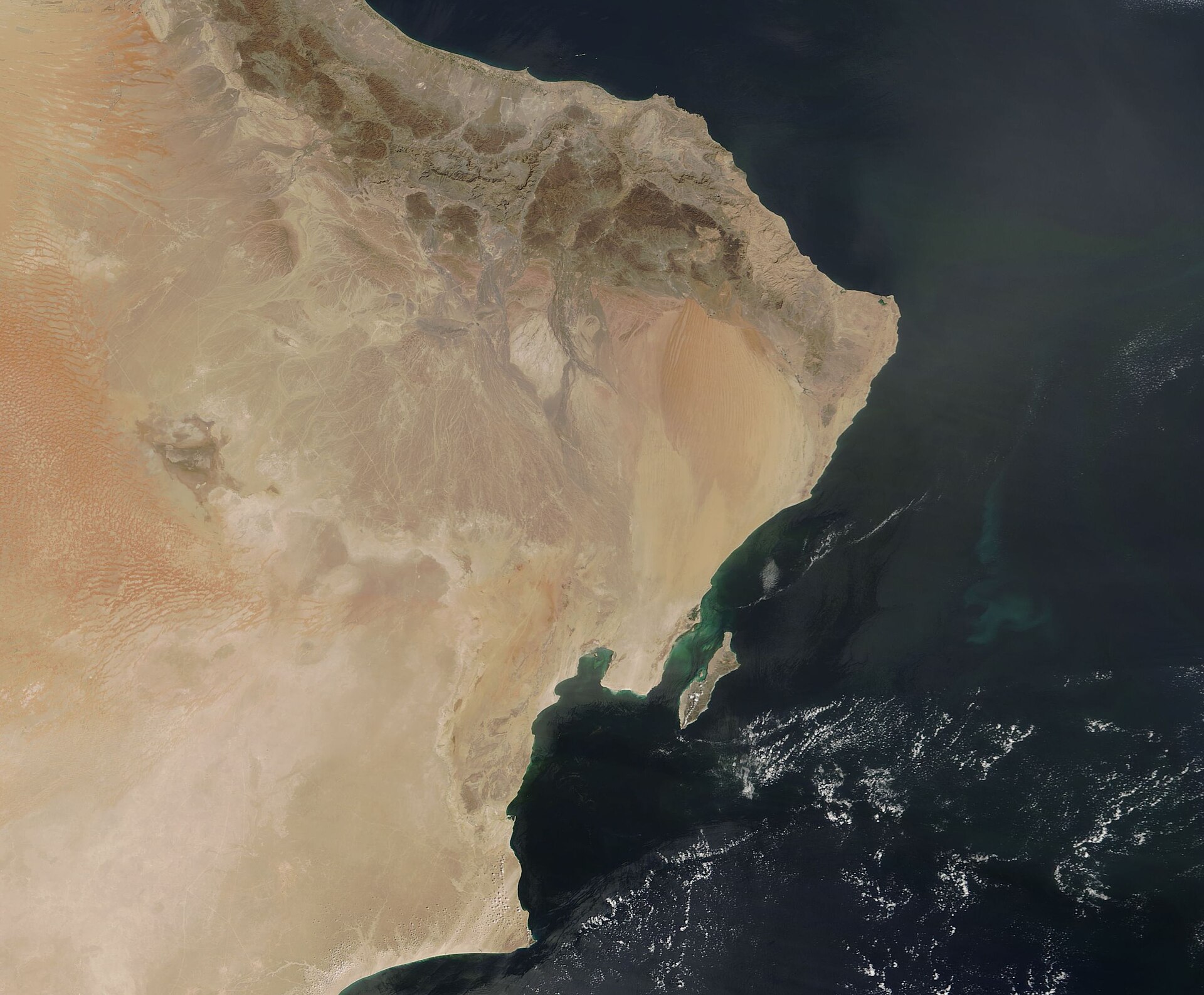 NASA MODIS satellite image of Oman's Musandam Peninsula and the Arabian Sea coast, showing Oman's strategic geographic position between Saudi Arabia and the Gulf of Oman