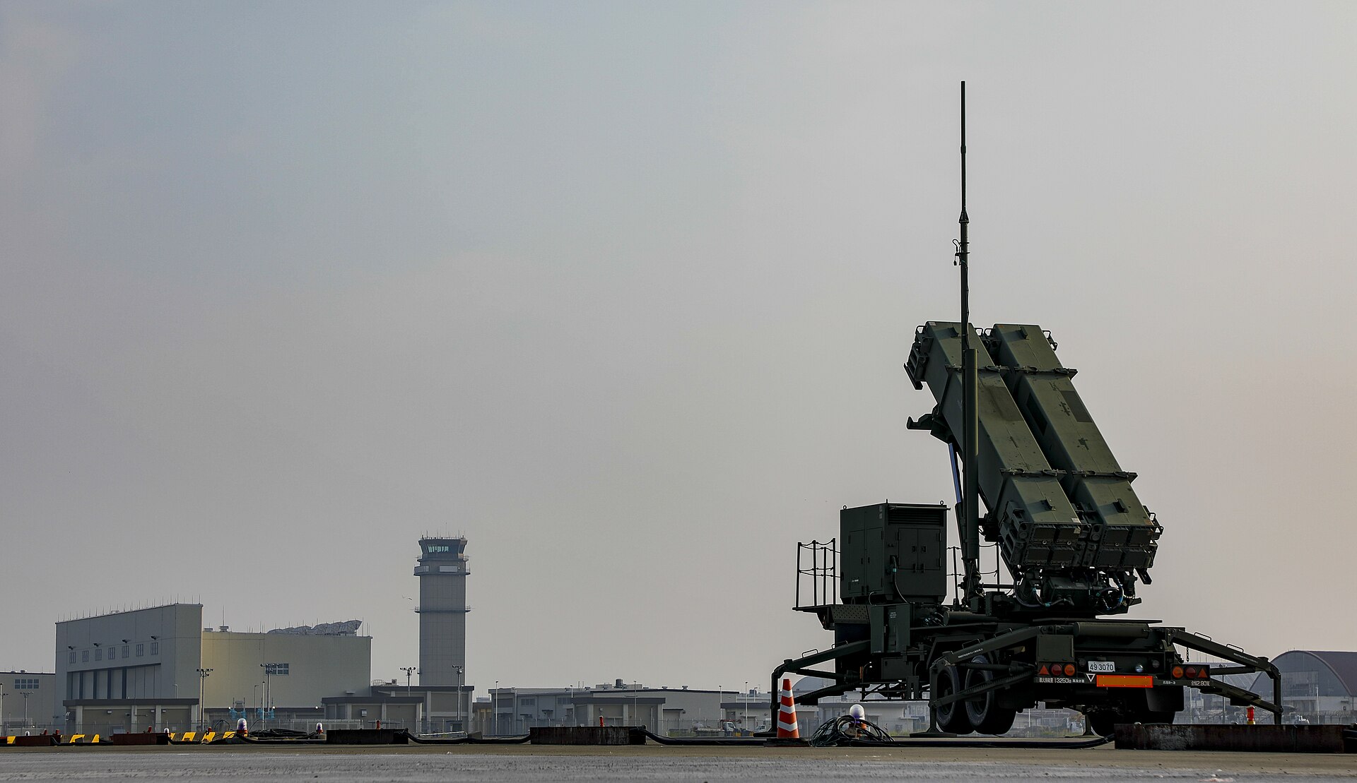 PAC-3 Patriot Advanced Capability-3 missile system deployed at Marine Corps Air Station Iwakuni Japan during JASDF training 2017 with airport control tower visible behind launcher