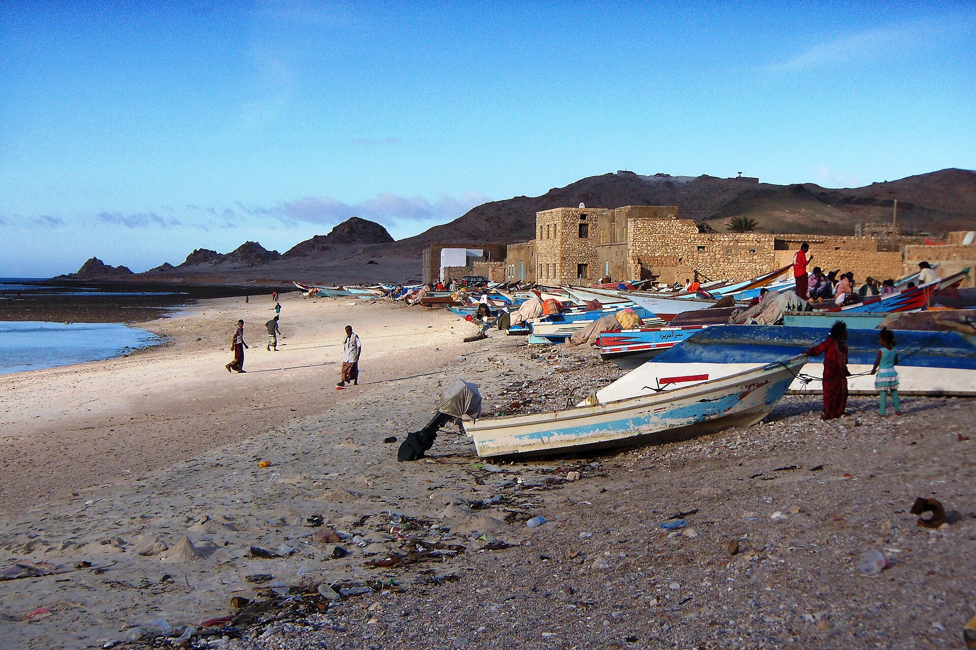 Yemeni fishermen and small fishing boats on the shore at Qalansiya village, Socotra Island, Yemen — the civilian maritime life the coalition warning targets