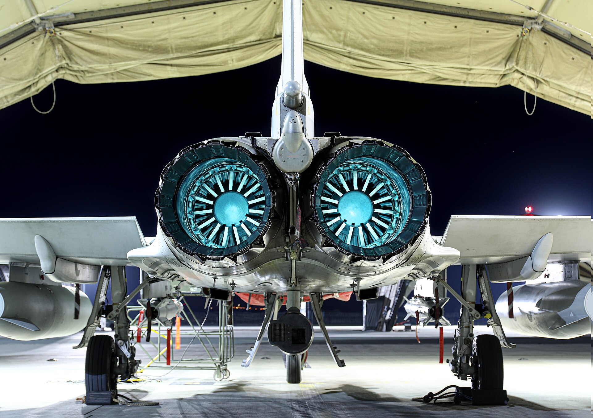 Close-up rear view of RAF Typhoon twin EJ200 engines glowing at night at RAF Akrotiri, Cyprus — the forward base that Iranian drones struck in March 2026