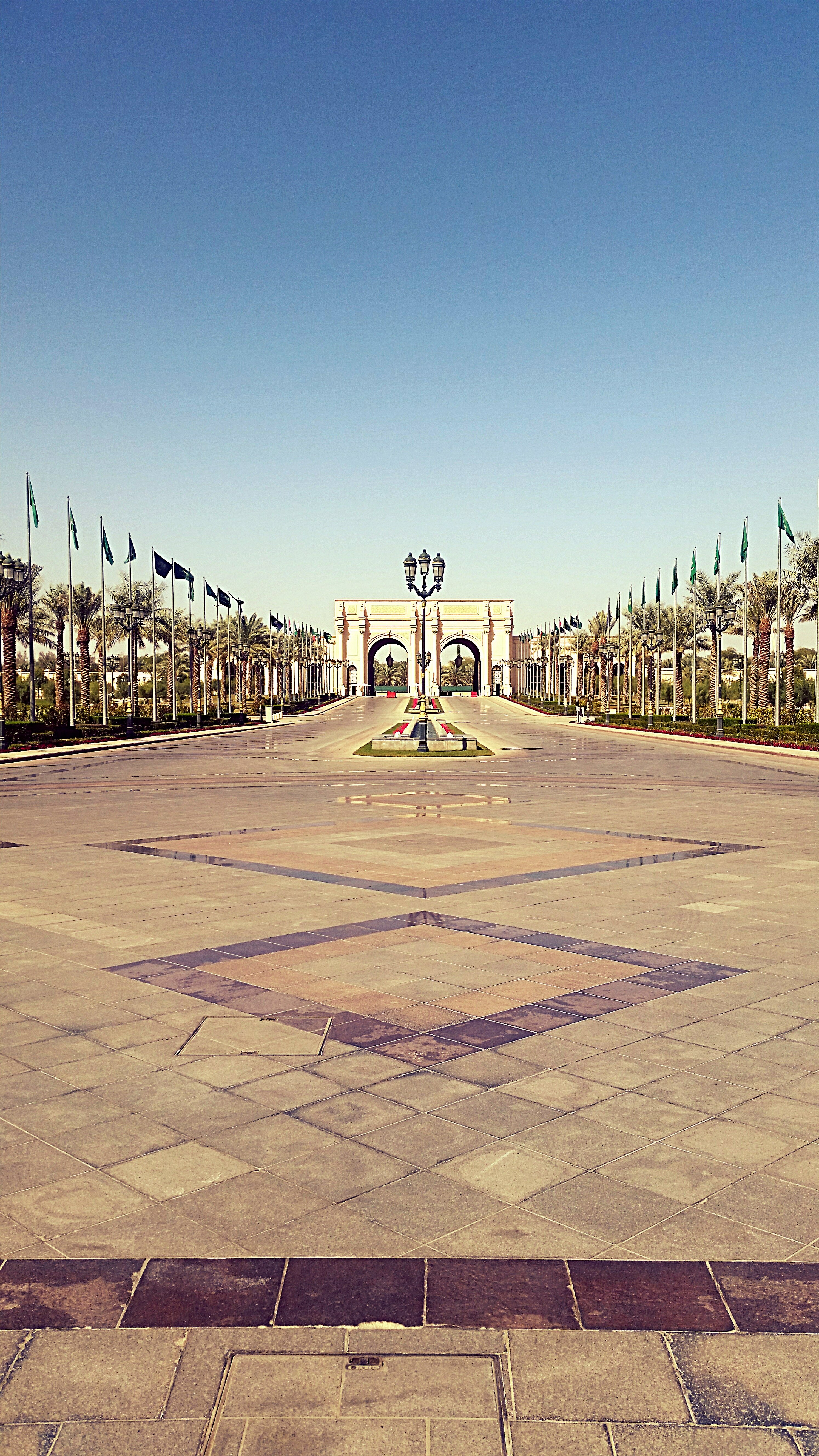 Ritz-Carlton hotel driveway in Riyadh lined with Saudi flags, venue of the Future Investment Initiative annual forum