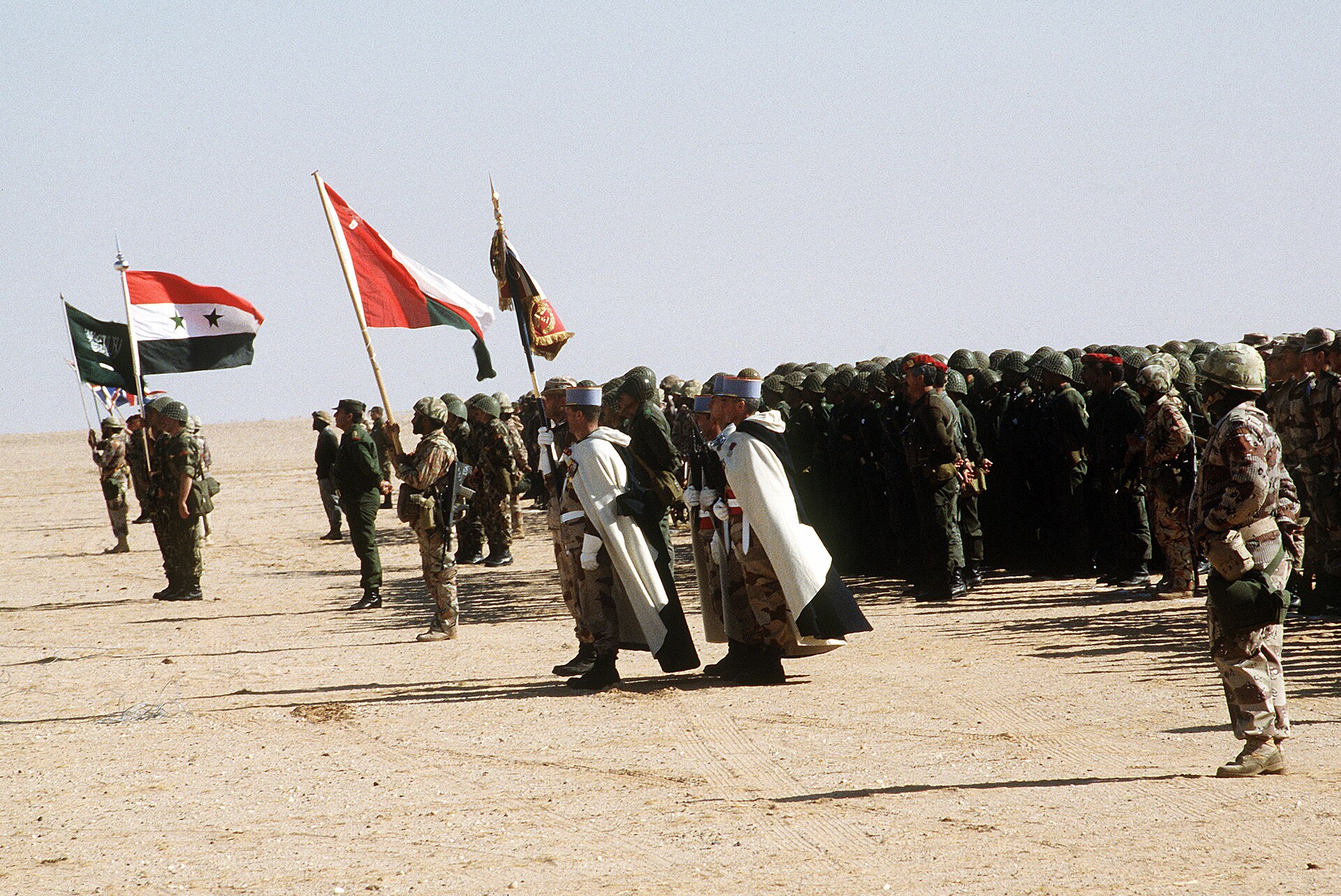 Multinational coalition forces assembled in Saudi Arabia for review by King Fahd during Operation Desert Storm, 1991 — flags from Syria, Oman and other Arab nations visible
