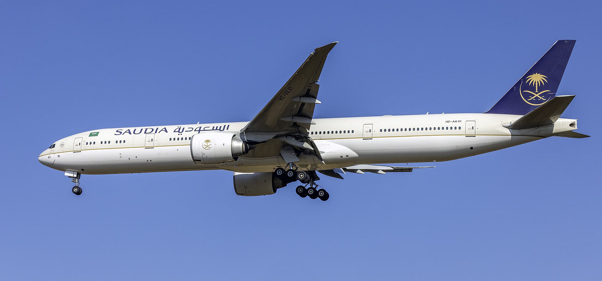 Saudia Boeing 777-300ER on final approach at Washington Dulles International Airport, with landing gear deployed. Saudi Arabia's national carrier is among the airlines whose Riyadh operations were suspended following Houthi strikes in October 2026.