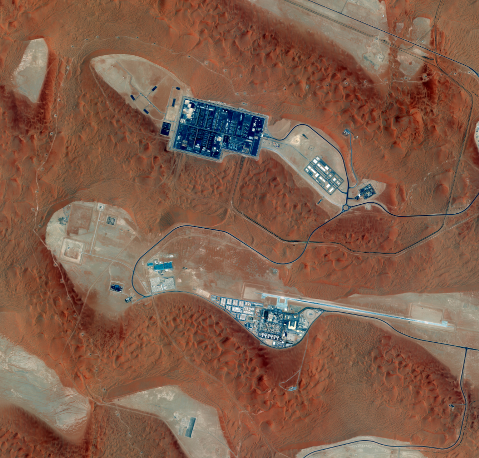 Satellite view of Shaybah oil field complex in the Empty Quarter desert — processing facilities and airstrip visible amid red sand dunes