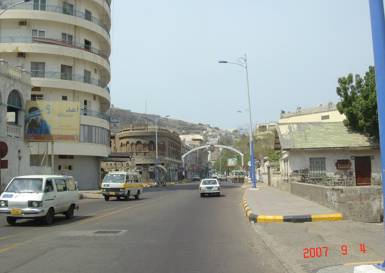 Main street through Tawahi district, western Aden, with the volcanic Shamsan ridge in the background — the coast guard building struck on 24 October stood in this neighbourhood