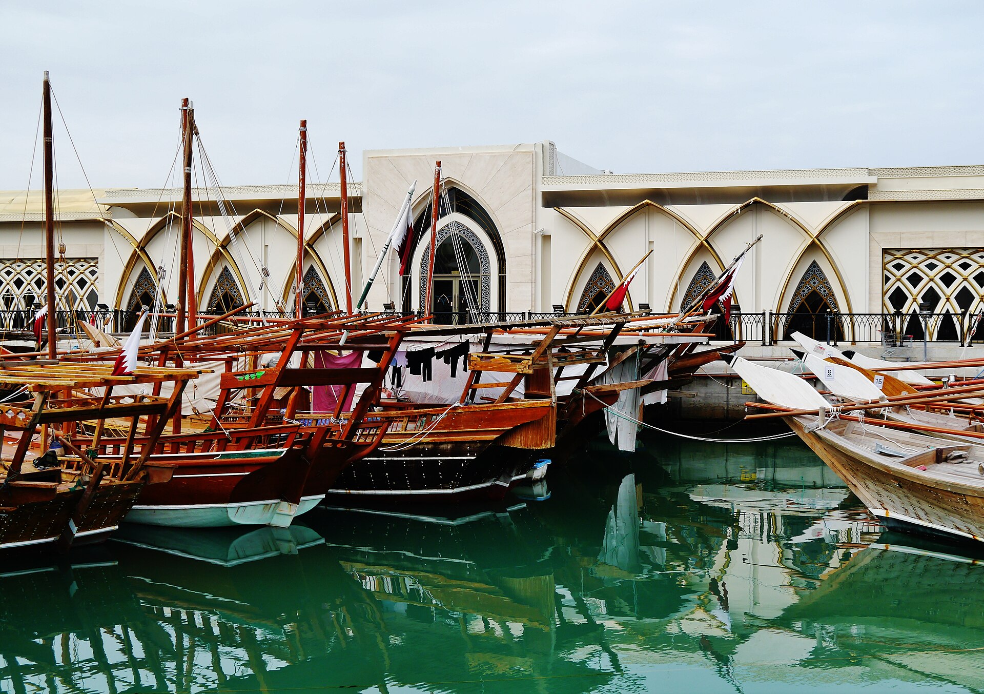 Traditional wooden Gulf dhows moored at Doha harbour showing Jalbah and Sanbuq vessel types used across Arabian Sea fishing routes