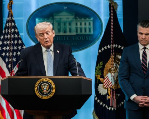 President Trump speaks at White House podium alongside Defense Secretary Hegseth during media briefing on Iran operations, April 2026