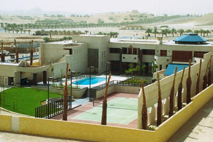 US Embassy compound in Riyadh, Saudi Arabia, showing the mission residence building, pool, tennis court and compound walls, photographed circa 1990