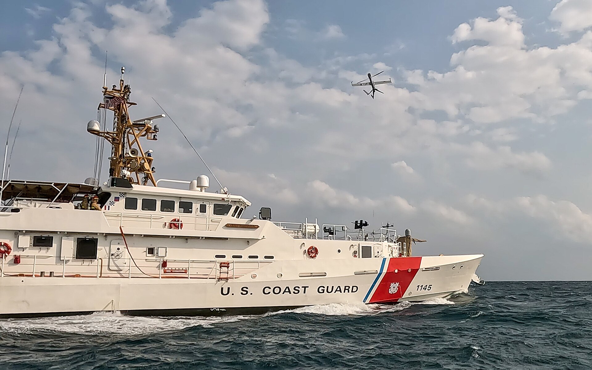US Coast Guard Sentinel-class fast response cutter USCGC Emlen Tunnell patrols the Arabian Gulf with surveillance drone overhead