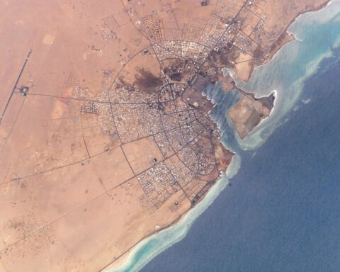 NASA satellite photograph of Yanbu al-Bahr on the Red Sea coast of Saudi Arabia — terminus of the East-West Crude Oil Pipeline and Saudi Aramco primary non-Hormuz crude export terminal