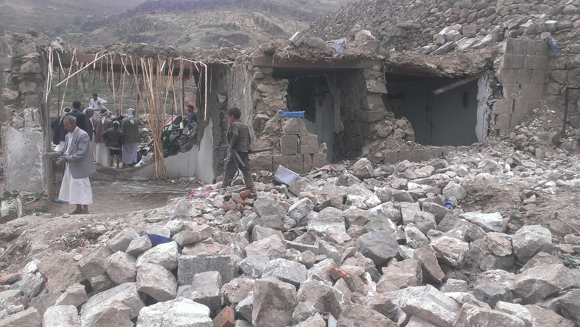 Yemeni civilians examine rubble of a stone home destroyed by an airstrike at Hajar Aukaish, Yemen, April 2015